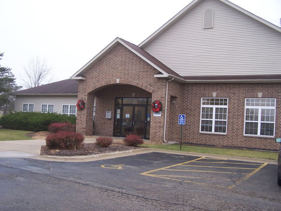 Front view of a brick building with a gabled roof and a main entrance.