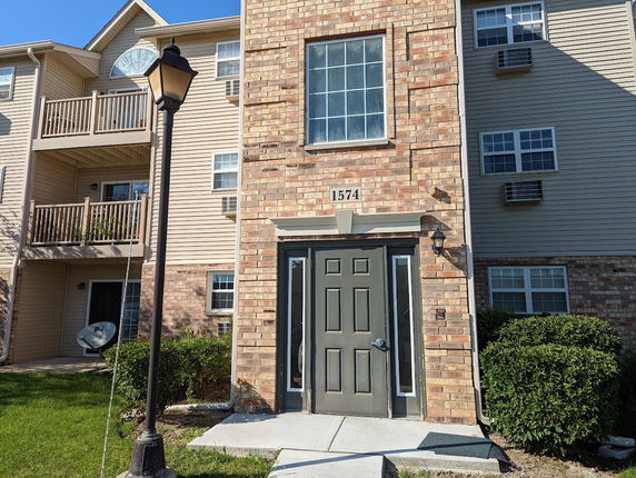Front view of a residential building with brick and siding exterior.