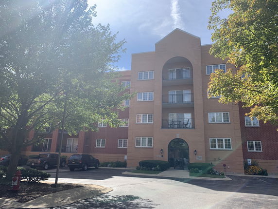 Front view of a multi-story apartment building with balconies.