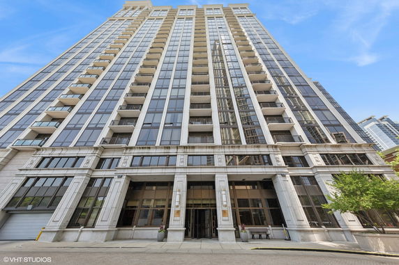 Front view of a tall, multi-story residential building with balconies.