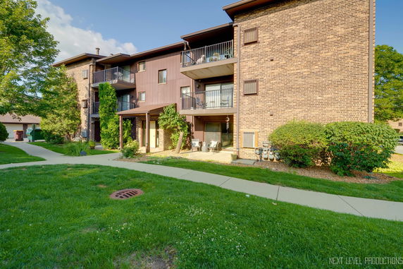 Front view of a multi-story brick apartment building with balconies.