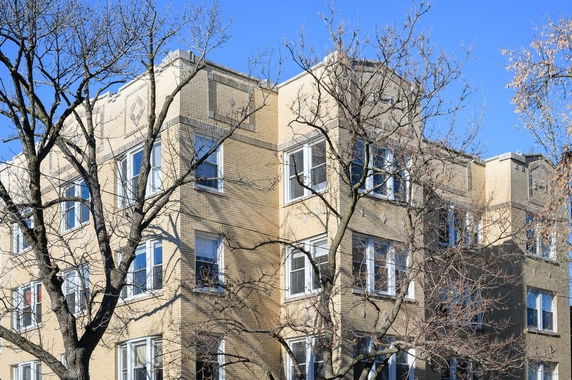 Front view of a multi-story residential apartment building with brick facade.