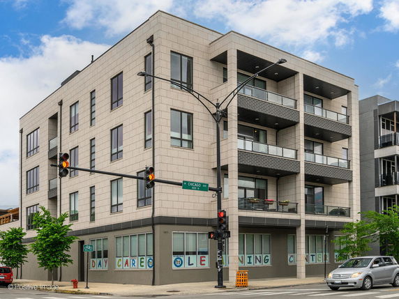 Front view of a modern multi-story building with large windows and balconies.
