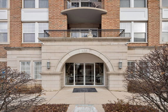 Front view of a multi-story brick building with an arched entrance.