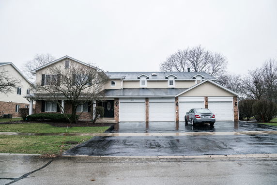 Front view of a two-story house with multiple garages.
