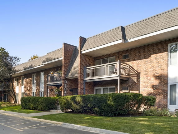 Front view of a brick apartment building with balconies.
