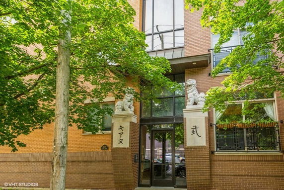 Front view of a building with brick facade and traditional statues by the entrance.