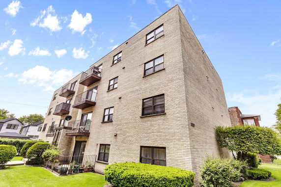 Front view of a multi-story apartment building with balconies.