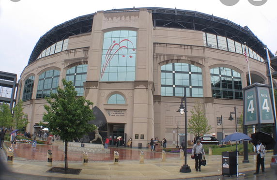 Front view of a large sports stadium with arched windows and multiple entrances.