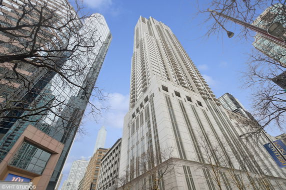 Front view of a tall modern skyscraper with multiple balconies.