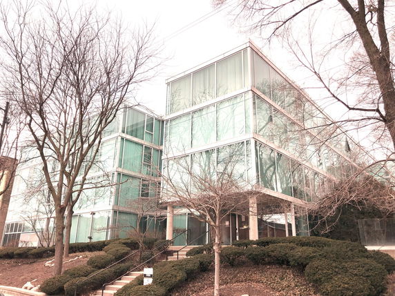 Front view of a modern multi-story office building with large glass windows.