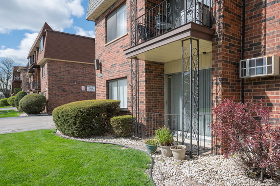 Front view of a brick apartment building with balconies.