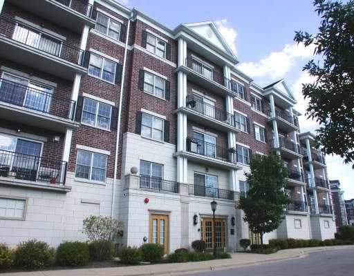 Front view of a multi-story brick apartment building with balconies.
