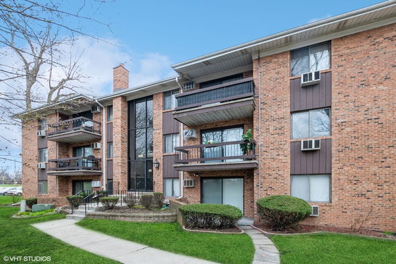 Front view of a multi-story apartment building with balconies.