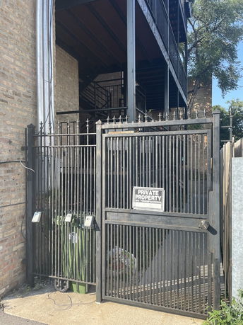 Front view of a multi-story building with metal fencing and private property sign.