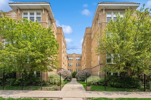 Front view of a multi-story brick building with decorative elements.