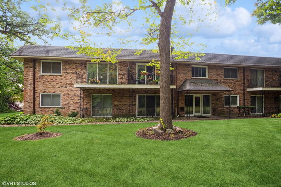 Front view of a two-story brick building with balconies and a central entrance.