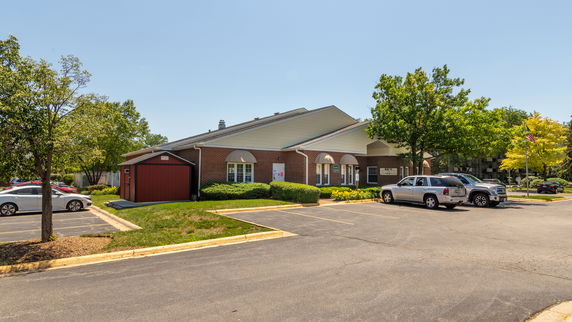 Front view of a building with a brick facade and parking area.
