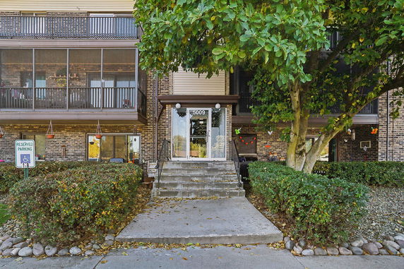 Front view of a multi-story building with a main entrance and balconies.