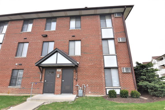 Front view of a three-story brick apartment building.