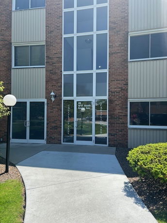 Front view of a multi-story building entrance with large windows.