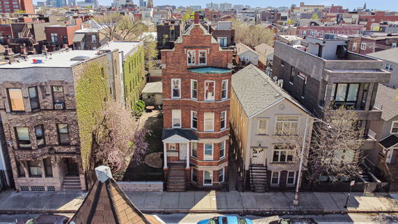 Front view of a tall, narrow brick building in an urban neighborhood.