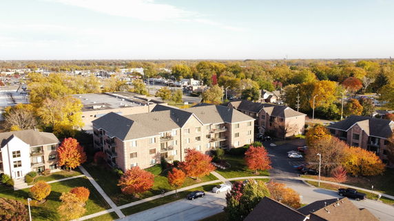 Elevated view of a residential area with multiple brick apartment buildings and trees in autumn colors.