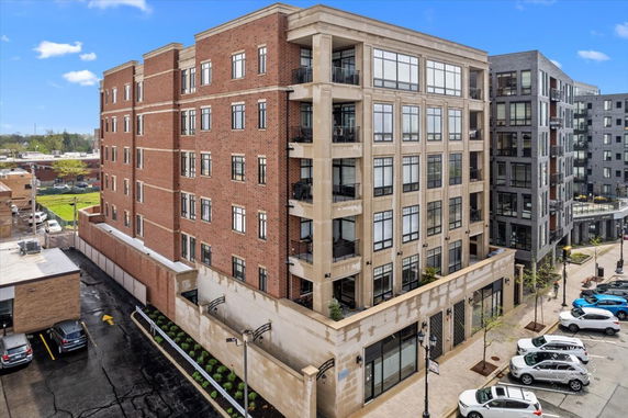 Front view of a multi-story brick building with large windows and balconies.