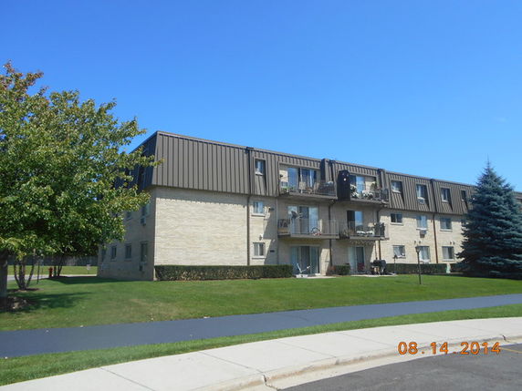 Front view of a multi-story residential building with balconies.