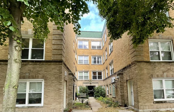 Front view of a multi-story brick building with symmetrical windows.