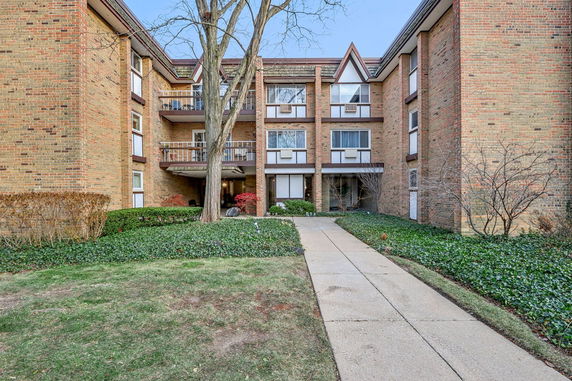 Front view of a multi-story brick building with balconies.