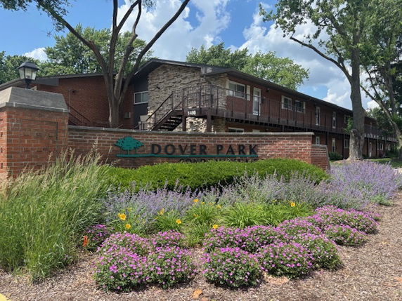 Front view of a multi-story building with a brick exterior and landscaped foreground.