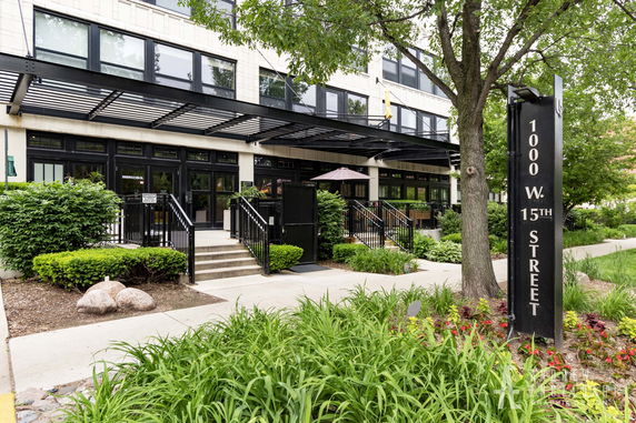 Front view of a modern building with multiple glass windows and a canopy over the entrance.