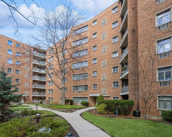 Front view of a multi-story brick apartment building with balconies.