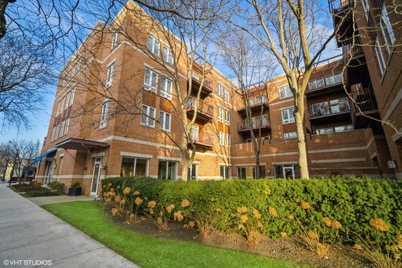 Front view of a multi-story brick building with balconies.