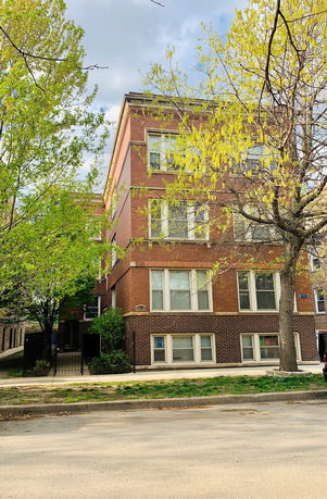 Front view of a brick apartment building with multiple floors.