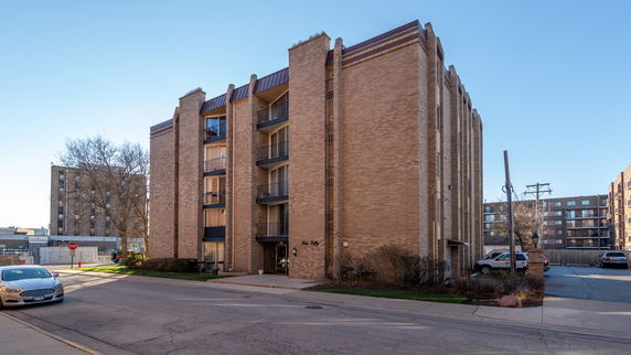 Front view of a multi-story apartment building with balconies.