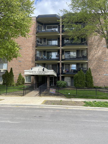 Front view of a multi-story condominium building with balconies.