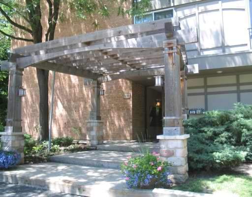 Front view of a building entrance with a wooden pergola.