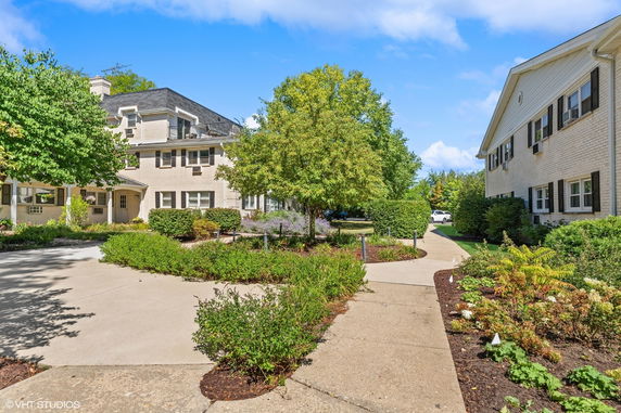 Front view of a multi-story building with a well-maintained garden path.
