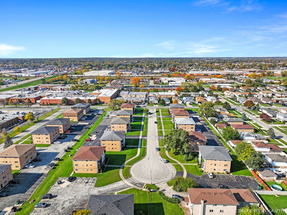 Aerial panoramic view of a residential area with multiple houses and apartment buildings.