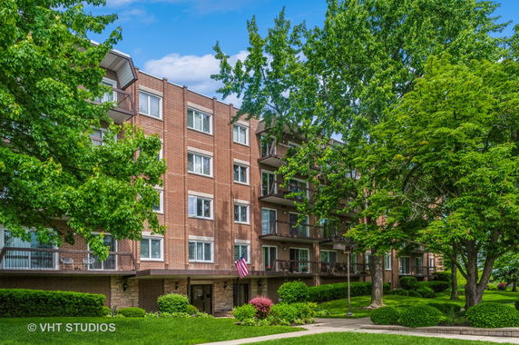 Front view of a multi-story brick apartment building with balconies.