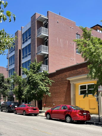 Front view of a multi-story building with brick facade and balconies.