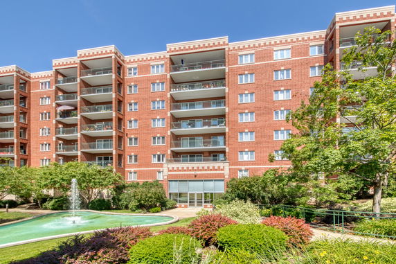 Front view of a multi-story brick apartment building with balconies.