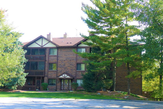 Front view of a brick apartment building with multiple floors and balconies.