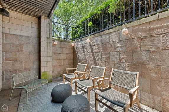 Outdoor patio area with chairs and decorative lighting.