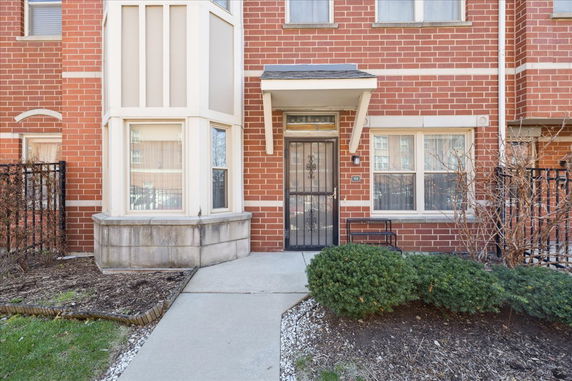 Front view of a brick townhouse with a small canopy over the entrance.