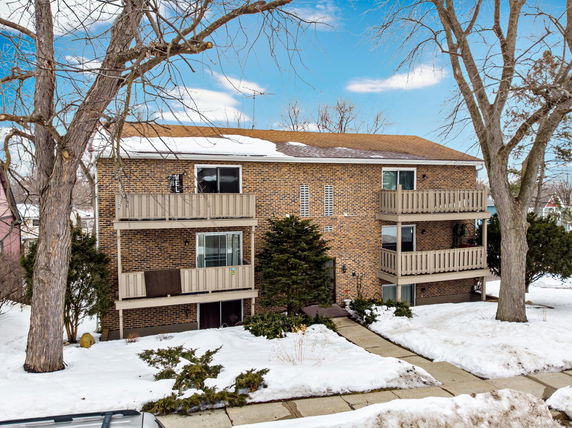 Front view of a brick apartment building with multiple balconies.