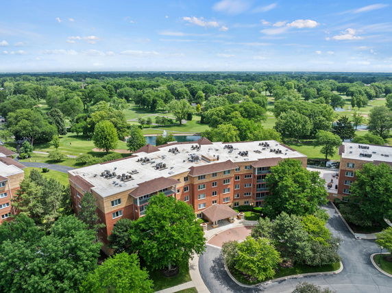 Panoramic view of a multi-story building surrounded by greenery and open space.