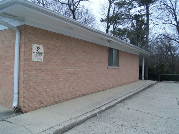 Side view of a brick building with a sloped roof.